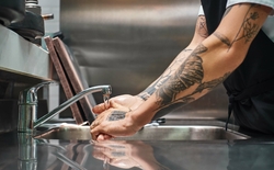 Jeune homme tatoué se lavant les mains